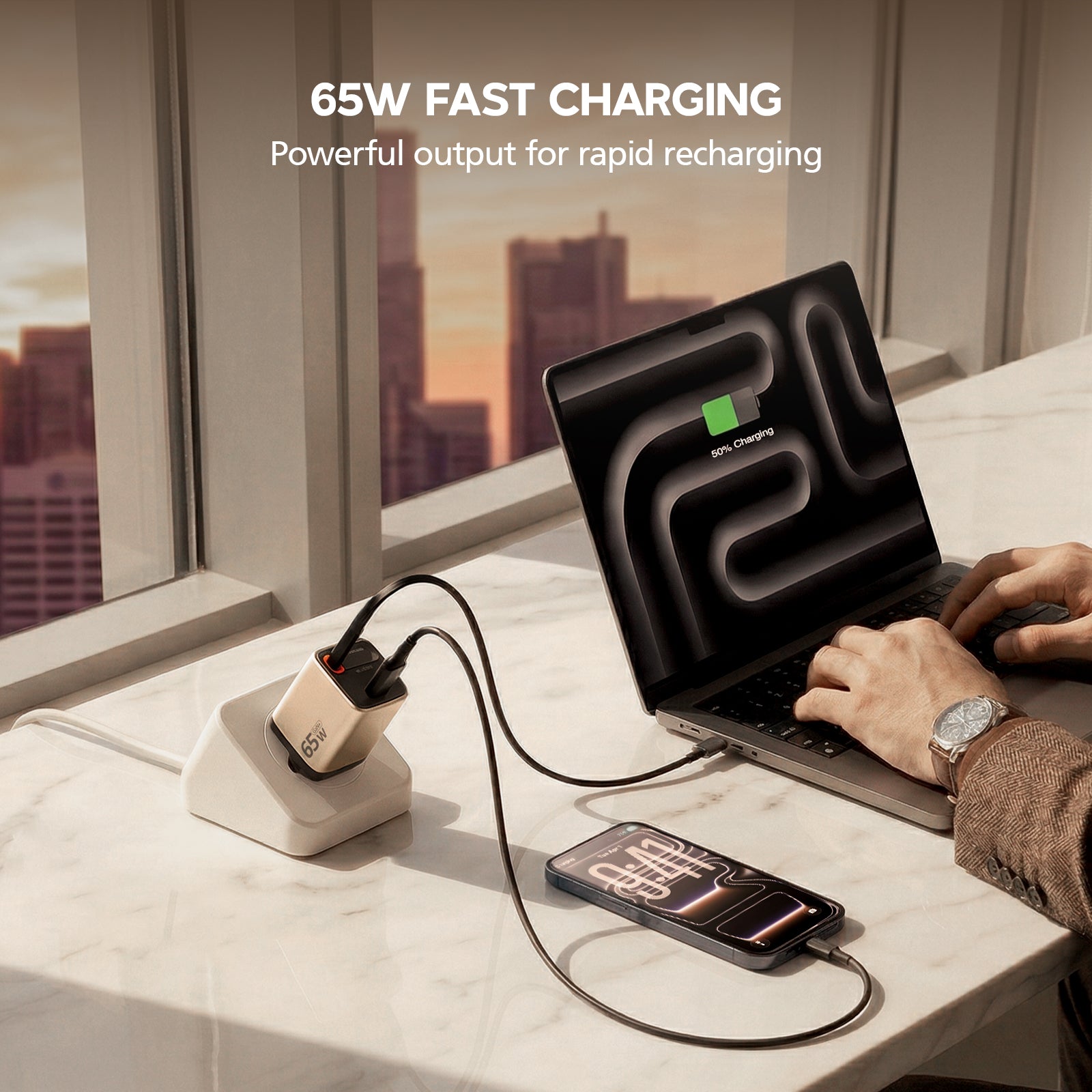 Person using a laptop with multiple devices charging on a desk, featuring 65W fast charging text.