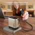 Person holding a retractable USB-C cable connected to a power bank on a wooden table.