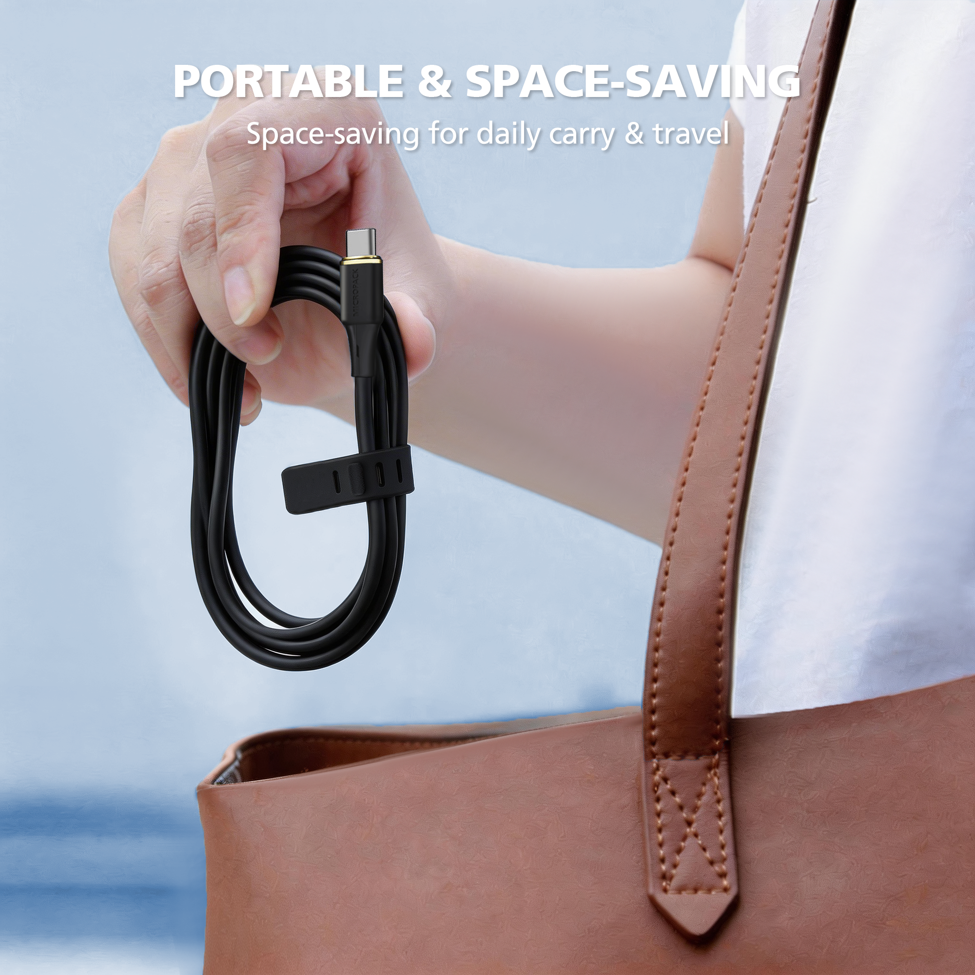 Hand holding a coiled cable next to a brown leather bag with text about portability and space-saving.