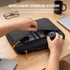 Person organizing a laptop and accessories into a black Intelligent Storage System case on a wooden desk.