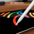 A close-up of a white stylus pen drawing on a tablet screen, with text at the top reading 'TILT SENSITIVITY' and smaller copy explaining that line thickness varies by tilt angle. The scene is set on a wooden surface.