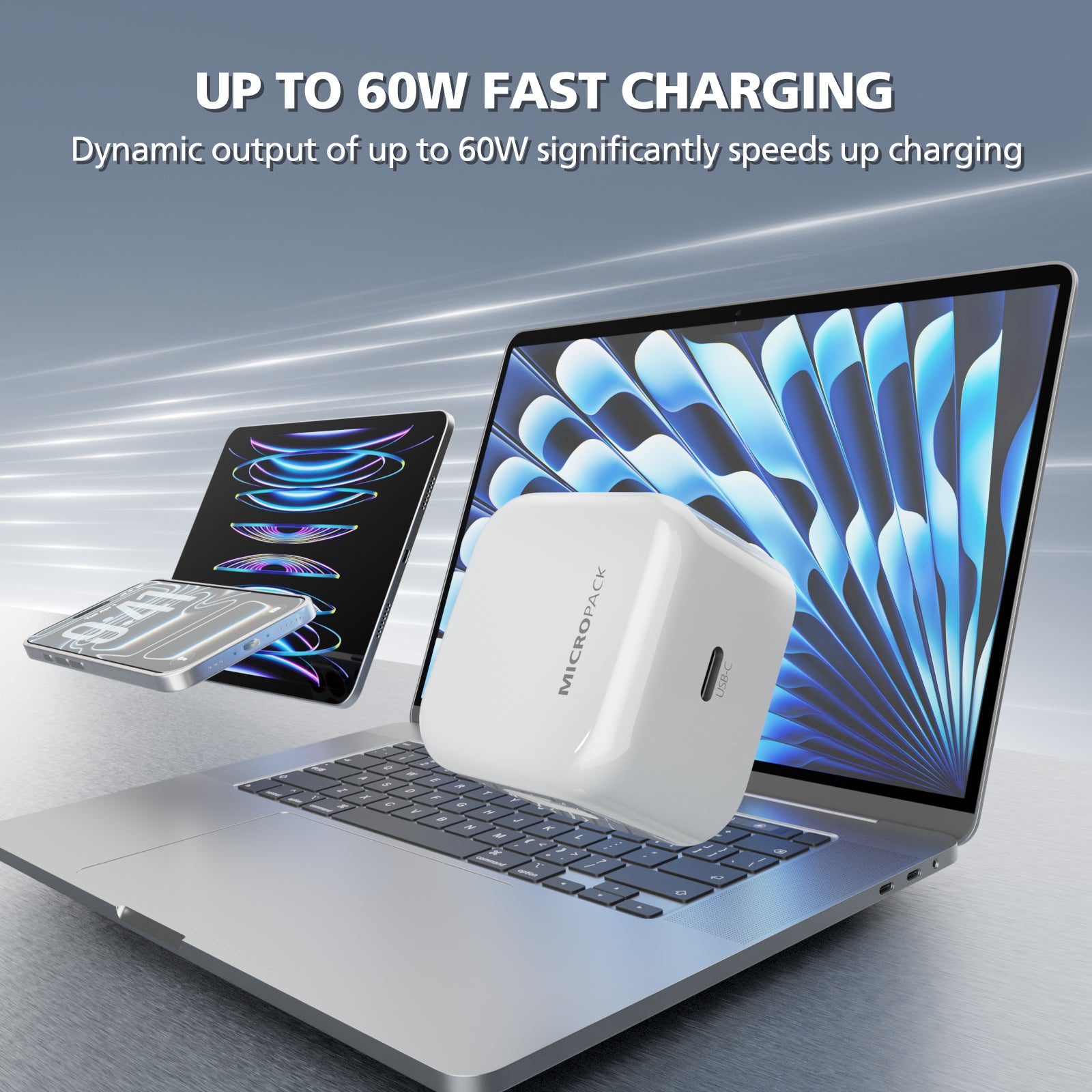 A white MICROPACK portable charger floating in front of an open silver laptop, with a tablet and battery pack shown nearby. Text at the top reads 'UP TO 60W FAST CHARGING' and describes dynamic output speedup charging.