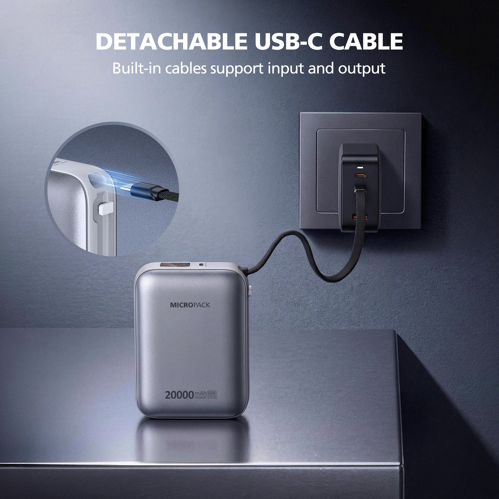 Power bank with detachable USB-C cable plugged into a wall outlet on a reflective surface.