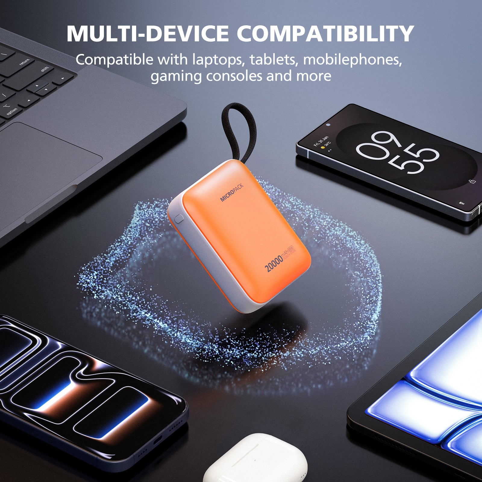 Orange power bank with text about multi-device compatibility on a black surface with electronic devices.