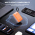 Orange power bank with text about multi-device compatibility on a black surface with electronic devices.